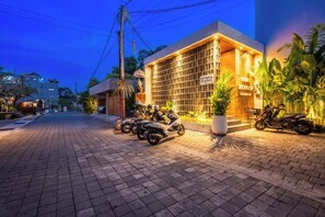 A building with a tiled entrance and parked scooters. - Casa Tropicale Seminyak (Bali)