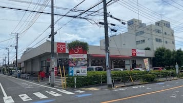 A street view with a building that has a sign for a pharmacy and a parking sign.