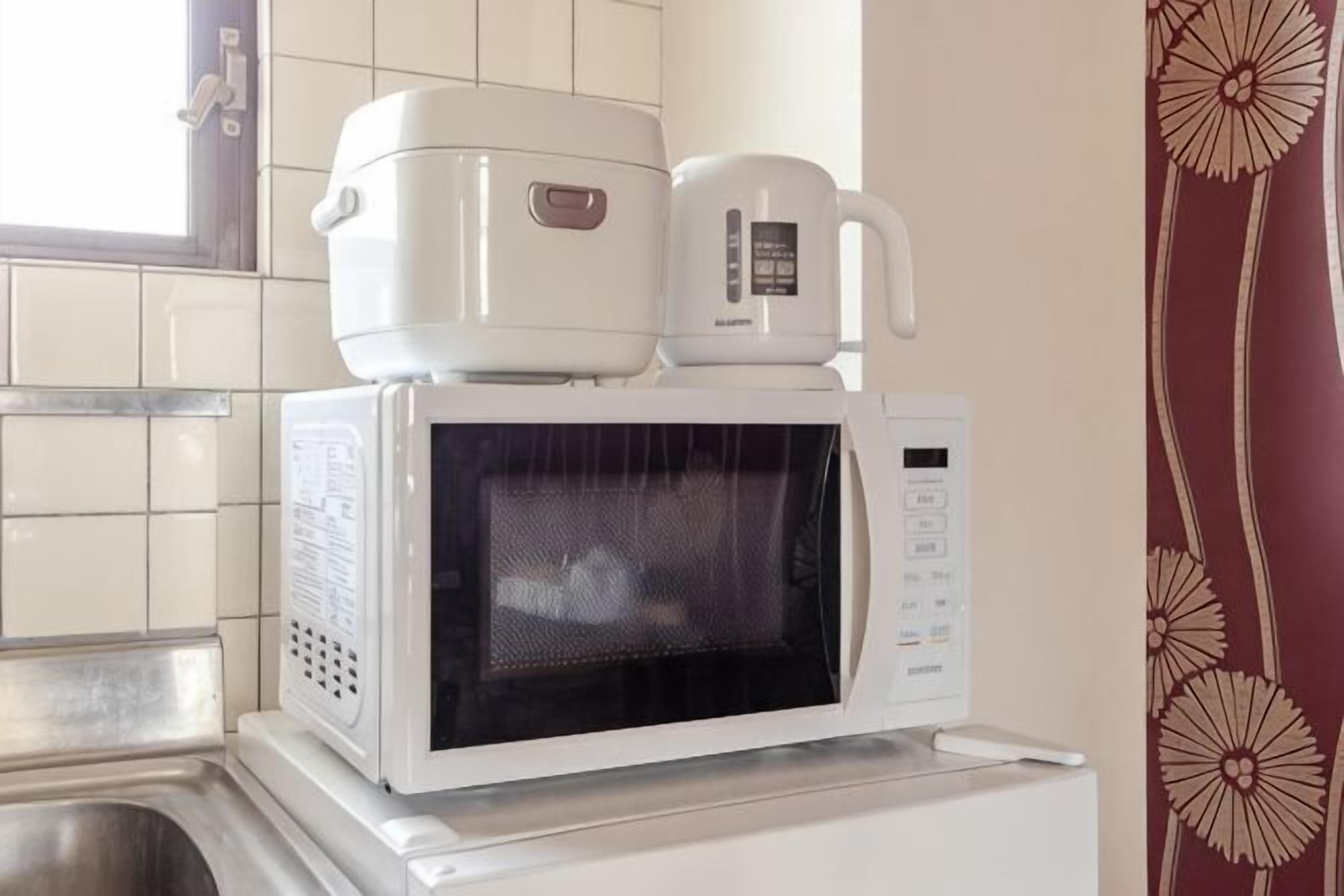 Una cucina con un forno a microonde e una cuociriso.