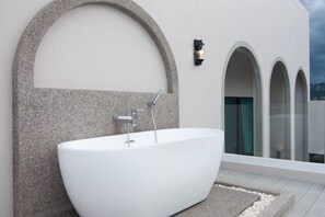 A modern bathroom with a freestanding bathtub, a stone wall, and a glass shower enclosure. - Nacha Pool Villa Cha-am (Cha-am)