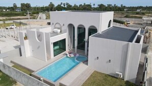 A modern house with a swimming pool, large windows, and a flat roof. - Nacha Pool Villa Cha-am (Cha-am)