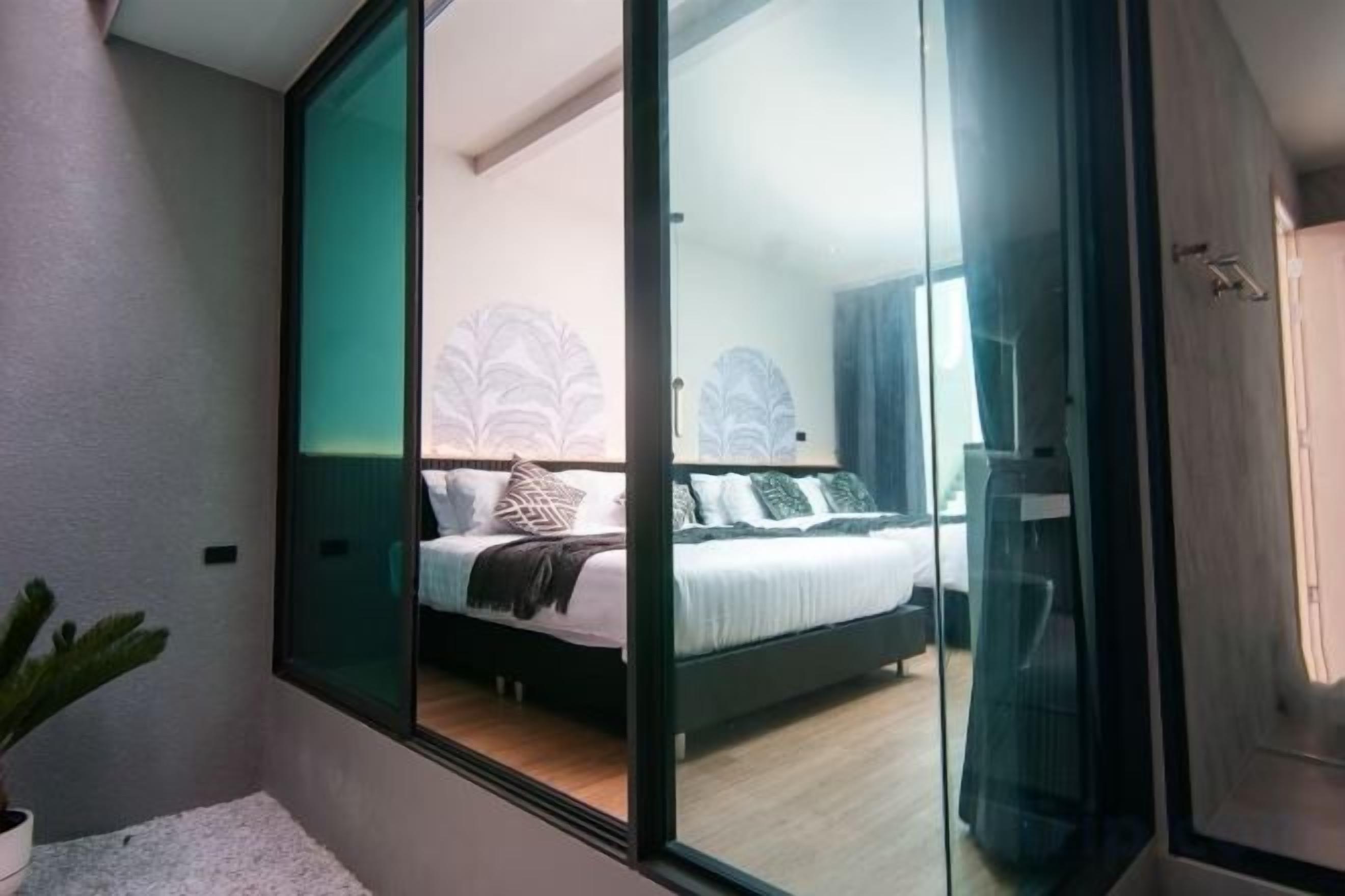 Quarto com cama, janela e planta em vaso.