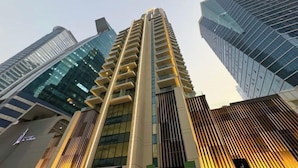 Un immeuble de grande hauteur doté d’une architecture moderne, caractérisé par une structure verticale imposante et une série de balcons.