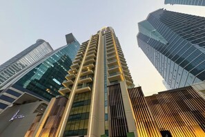 Un edifici alt amb un disseny arquitectònic modern, que destaca per una estructura vertical imponent i una sèrie de balcons.