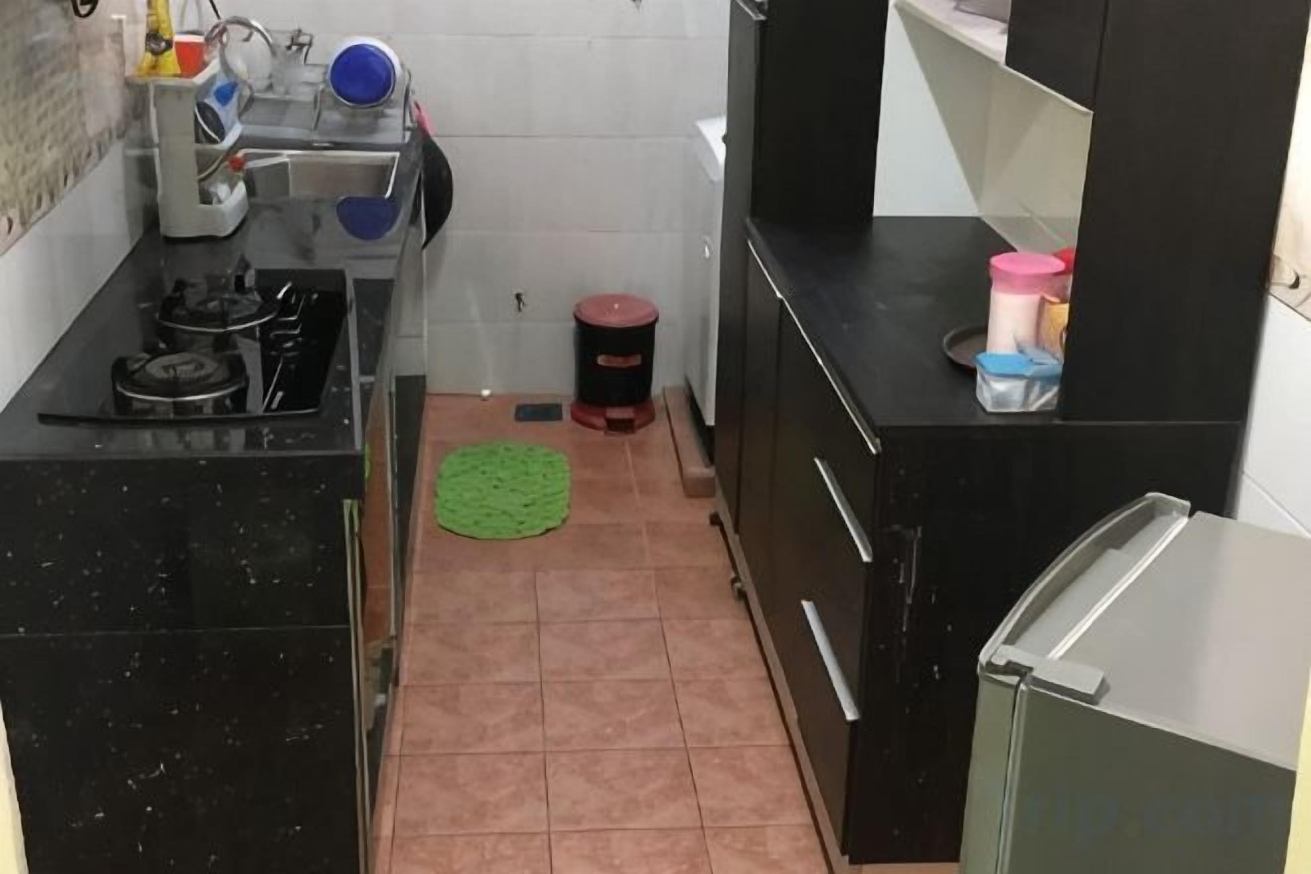 A compact kitchen with a gas stove, sink, and a refrigerator.