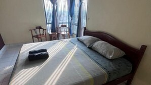 A single bed with a mattress and pillows, a wooden headboard, and a small table with chairs. - Mahasa Homestay Kuala Lumpur (Kuala Lumpur)
