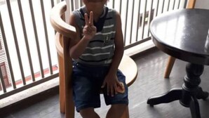 A child sitting on a wooden chair in a room with a round black table. - Mahasa Homestay Kuala Lumpur (Kuala Lumpur)