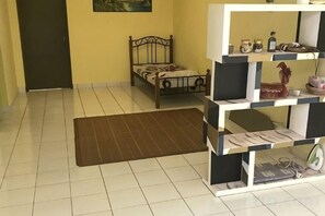 Una habitación con una cama, un tapete y un mueble de almacenaje con estantes.