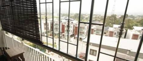 A balcony with a view of buildings and a railing.