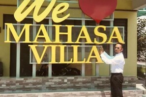 A person standing in front of a building with large yellow letters spelling 'We Mahasa Villa'. - Mahasa Homestay Kuala Lumpur (Kuala Lumpur)