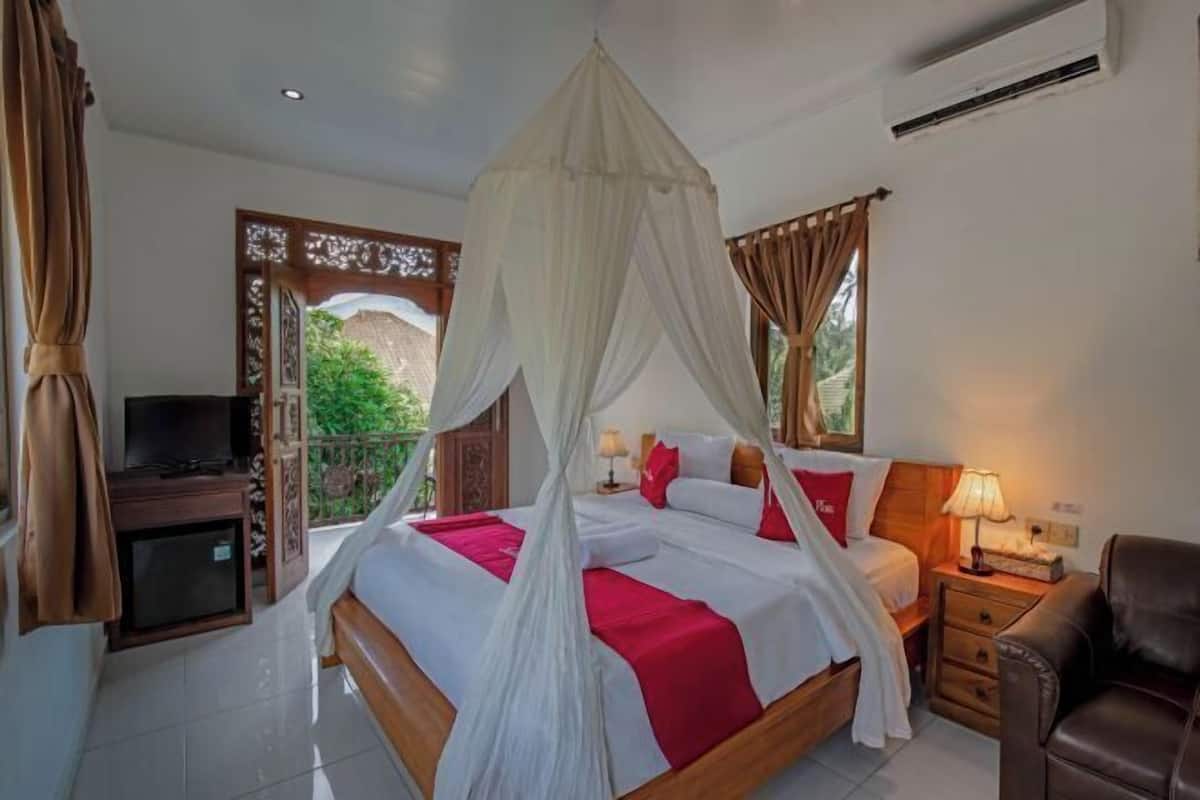 A bedroom with a bed, bedside table, TV, and curtains.