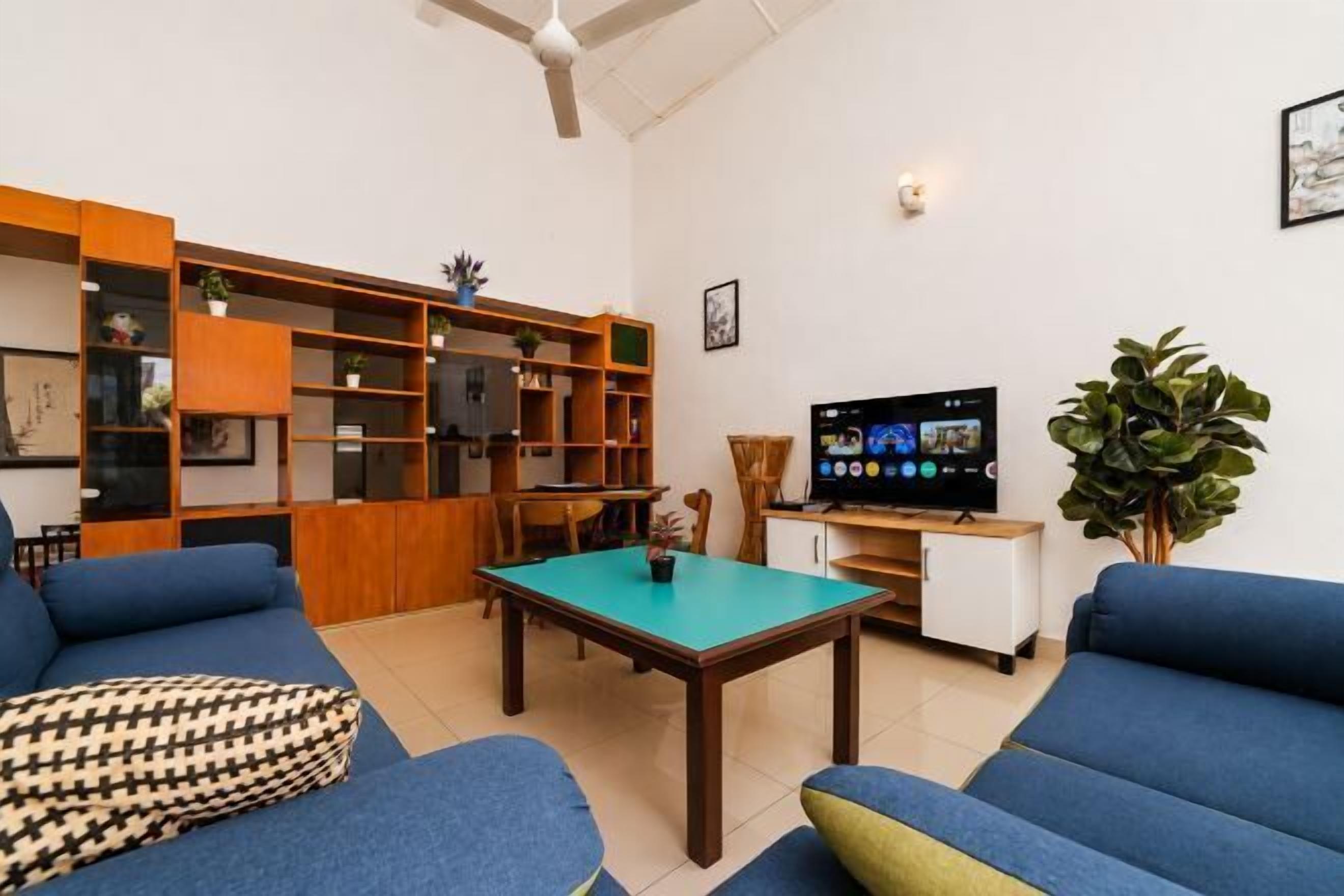 A living room with a sofa, a coffee table, a TV, and a bookshelf.