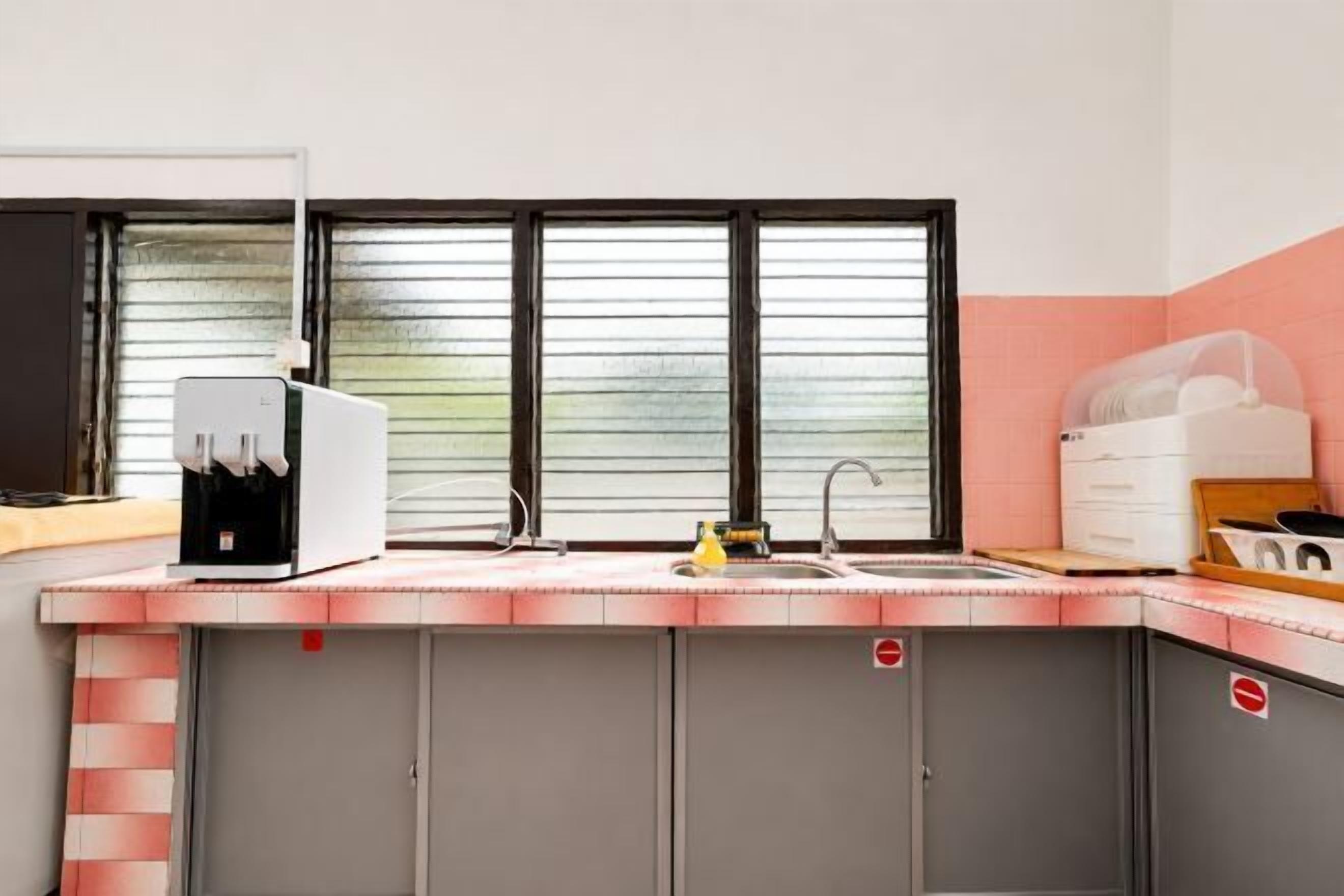 A kitchen with a built-in coffee machine, a sink, and cabinets.
