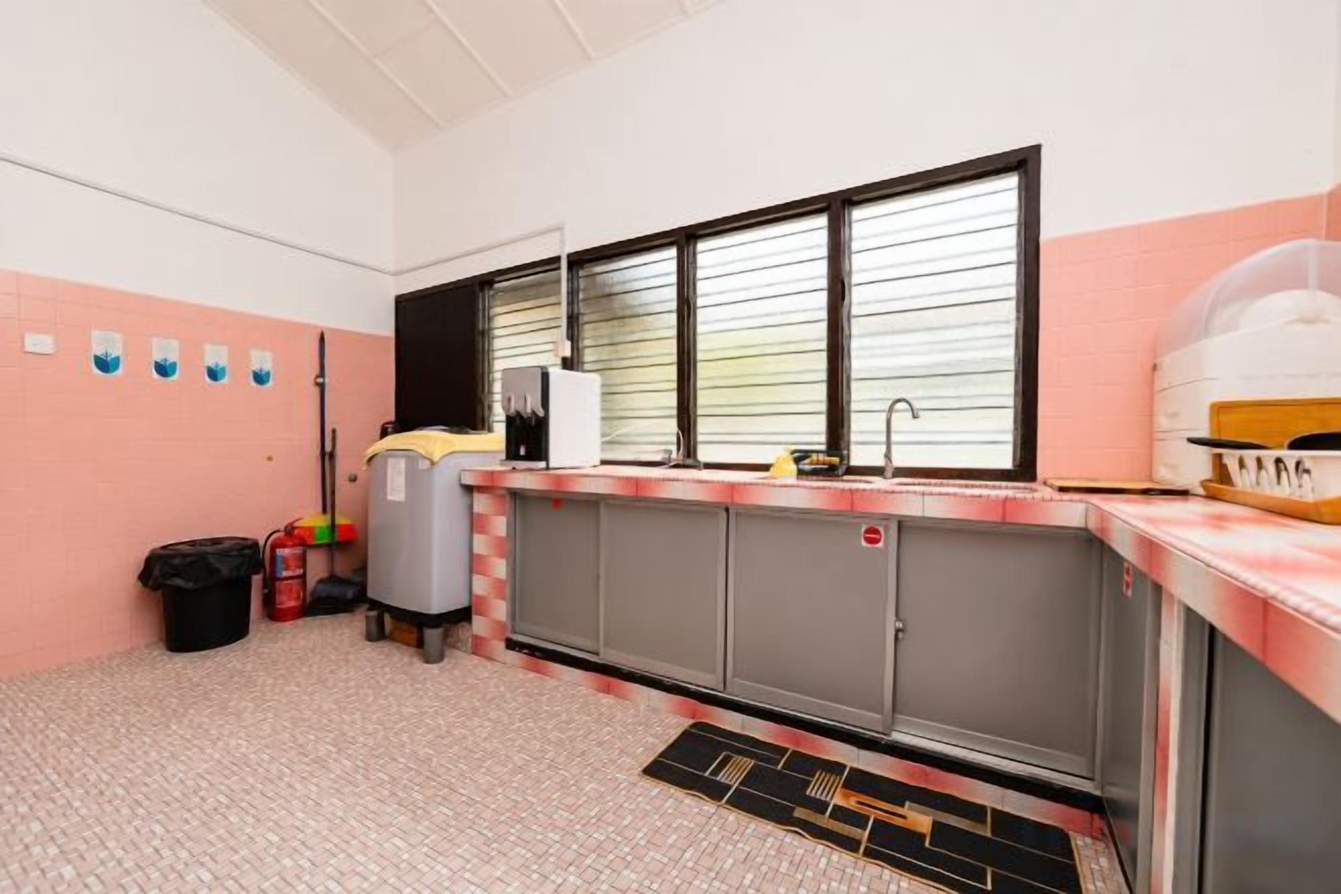 A kitchen with a sink, a refrigerator, and a window with blinds.