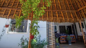 A thatched roof structure with a hanging plant.