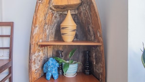 A rustic wooden shelf with a vase, a blue decorative item, and a potted plant.
