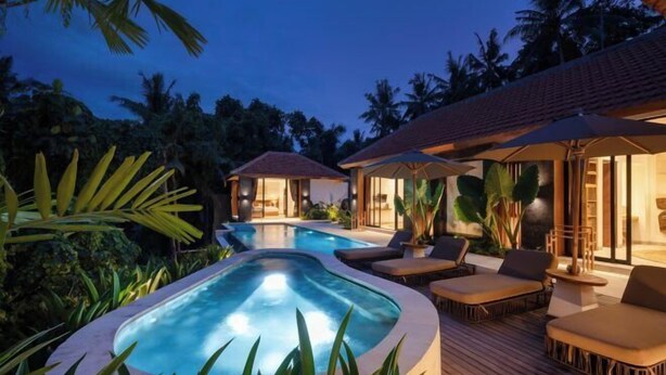 A pool area with lounge chairs and a hot tub, surrounded by tropical plants and palm trees. - Villa Le Lotus Bleu by BaliSuperHost (Bali)