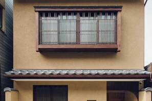 A building with a tiled roof, a window with a wooden frame, and a balcony. - Asahi House Kyoto（Dog Friendly） (Kyoto)