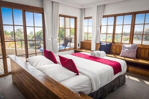 A hotel room with a large bed, a bench with pillows, and a view of the outdoors. - Samastiti Bingin Luxury appartements steps from the beach (Bali)