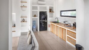 Una cocina moderna con electrodomésticos integrados, encimera de madera y horno empotrado.