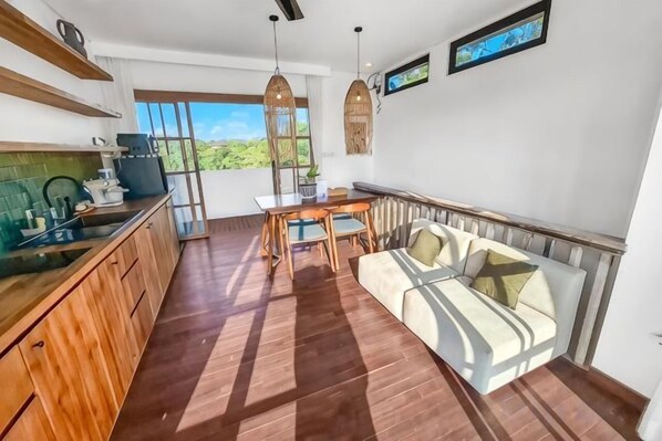 Una cocina moderna con armarios de madera y un comedor con sofá y mesa.