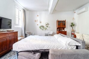 A bedroom with a large bed, a TV, a wooden dresser, and a desk with a chair. - Oasis in the Center of Bologna (Bologna)