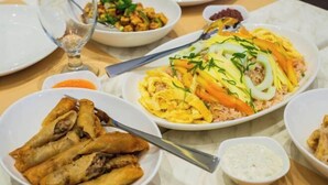 A table with various dishes including fried items, rice, and vegetables. - The Manaoag Hotel (Manaoag)