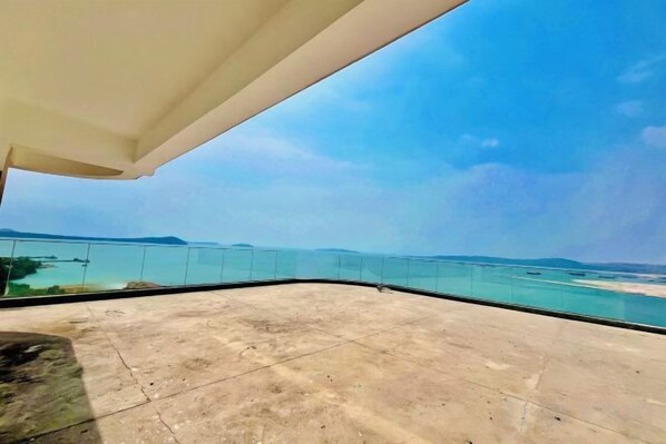 A balcony with a clear view of the sea and distant islands. - HC HOTEL (Prey Nob)