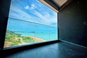 A room with a large window overlooking a coastal landscape. - HC HOTEL (Prey Nob)