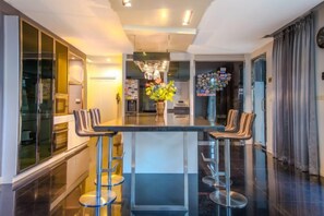 Una cucina moderna con isola centrale, sgabelli da bar e lampadario.