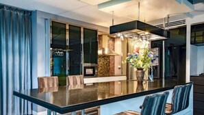 Une cuisine moderne dotée d’un grand îlot central, de tabourets de bar et d’un vase décoratif.