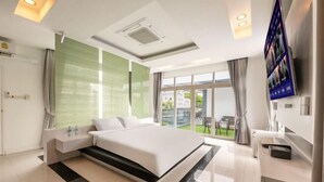 Une chambre d’hôtel moderne dotée d’un grand lit, d’une télévision, d’un balcon et d’une salle de bain.