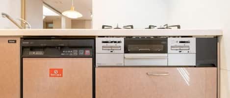 A kitchen with a dishwasher, a coffee machine, and a built-in oven.