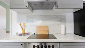 Une cuisine équipée d’une cuisinière, d’une planche à découper en bois et d’un rouleau d’essuie-tout.