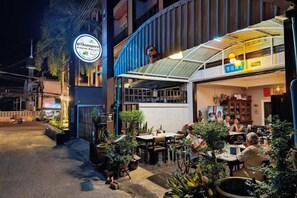 A restaurant with outdoor seating, a covered area, and a sign indicating it's a transport hub. - C-View Residence by Apartwell (Pattaya)