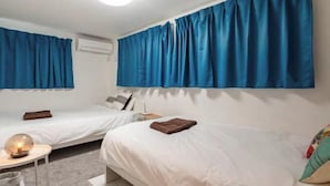 A hotel room with two beds, white bedding, a small table with a lamp, and blue curtains. - Coast Nishikōjiya (Tokyo)