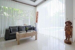 Una sala moderna con un sofá, una mesa de centro y una estatua.
