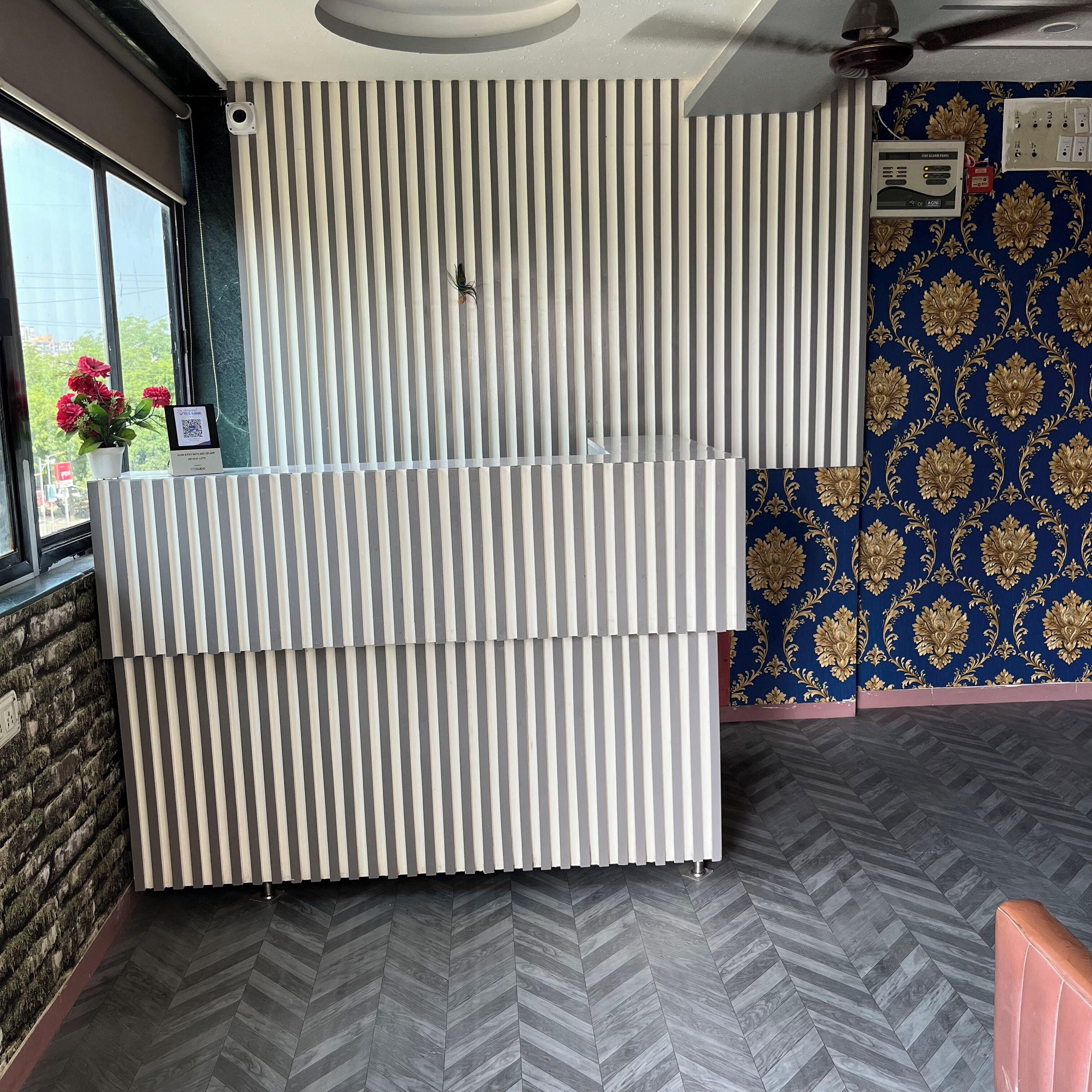 Una habitación con pared a rayas, radiador, pared estampada y suelo tipo espiga.