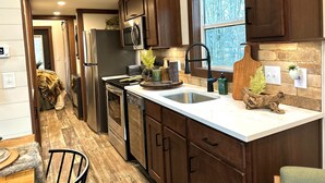 Una cocina moderna con electrodomésticos de acero inoxidable, armarios de madera y un amplio ventanal que proporciona luz natural.