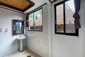 Ein Badezimmer mit Waschbecken, Spiegel und Fenster.