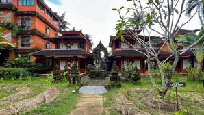 A traditional courtyard with two buildings, a central pathway, and a statue. - RedDoorz @ Garden Suly Villa Peliatan Ubud (Bali)