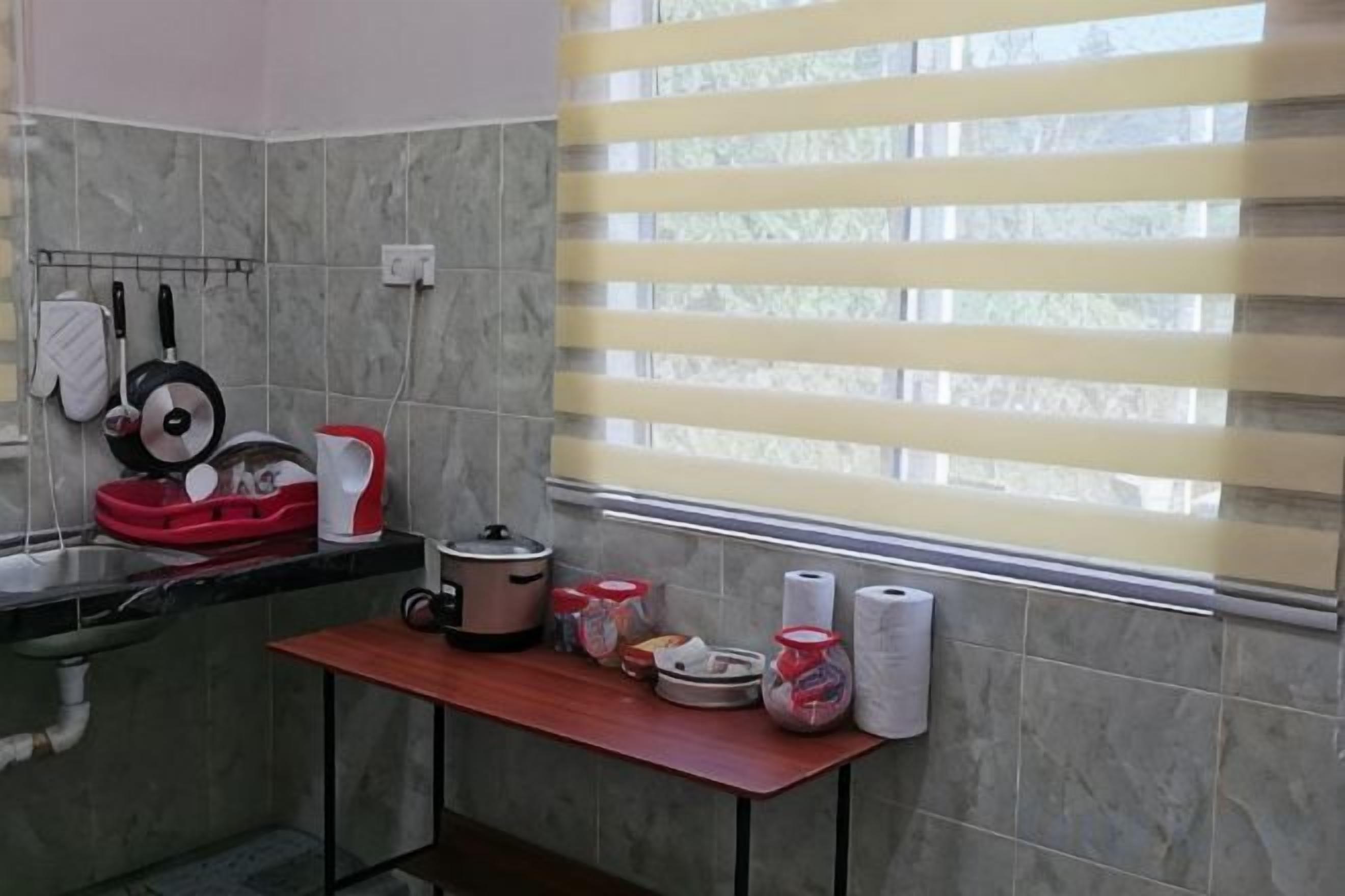 A kitchen with a window, a sink, and various kitchen items on the counter.