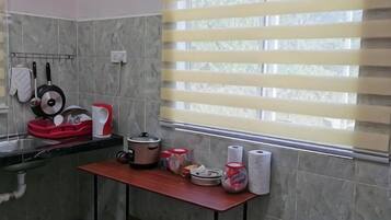A kitchen with a window, a sink, and various kitchen items on the counter.