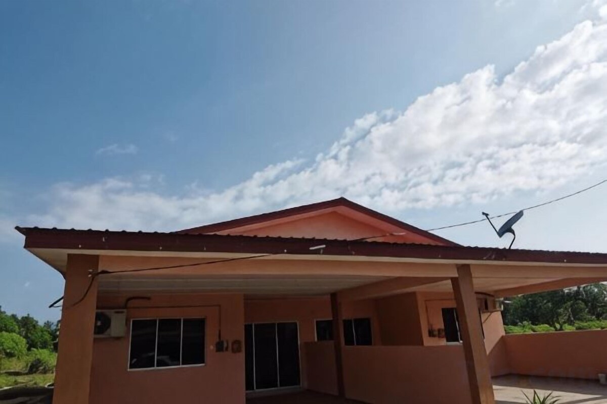 A building with a covered patio area, a red roof, and a clear sky.