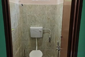 A bathroom with a toilet, a sink, and a shower. - Homestay Che Naa (Kuala Kuantan)