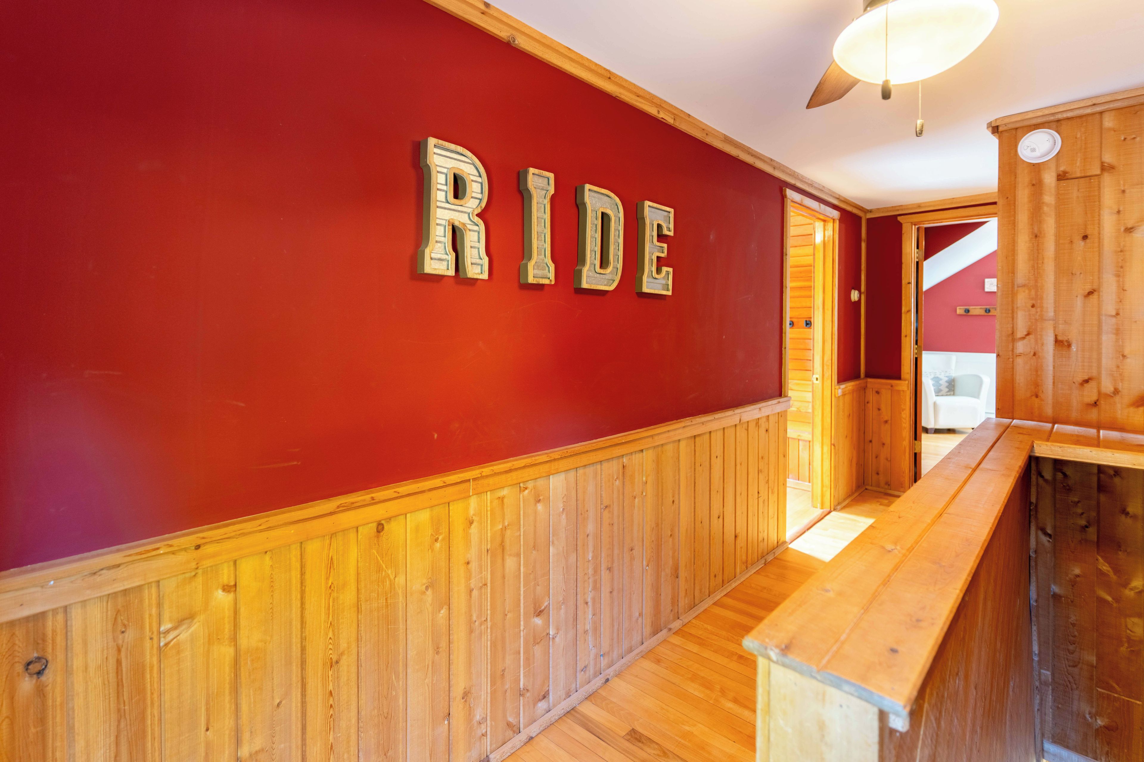 A hallway with a wooden bench and a red wall with the word 'RIDE' spelled out in large letters.