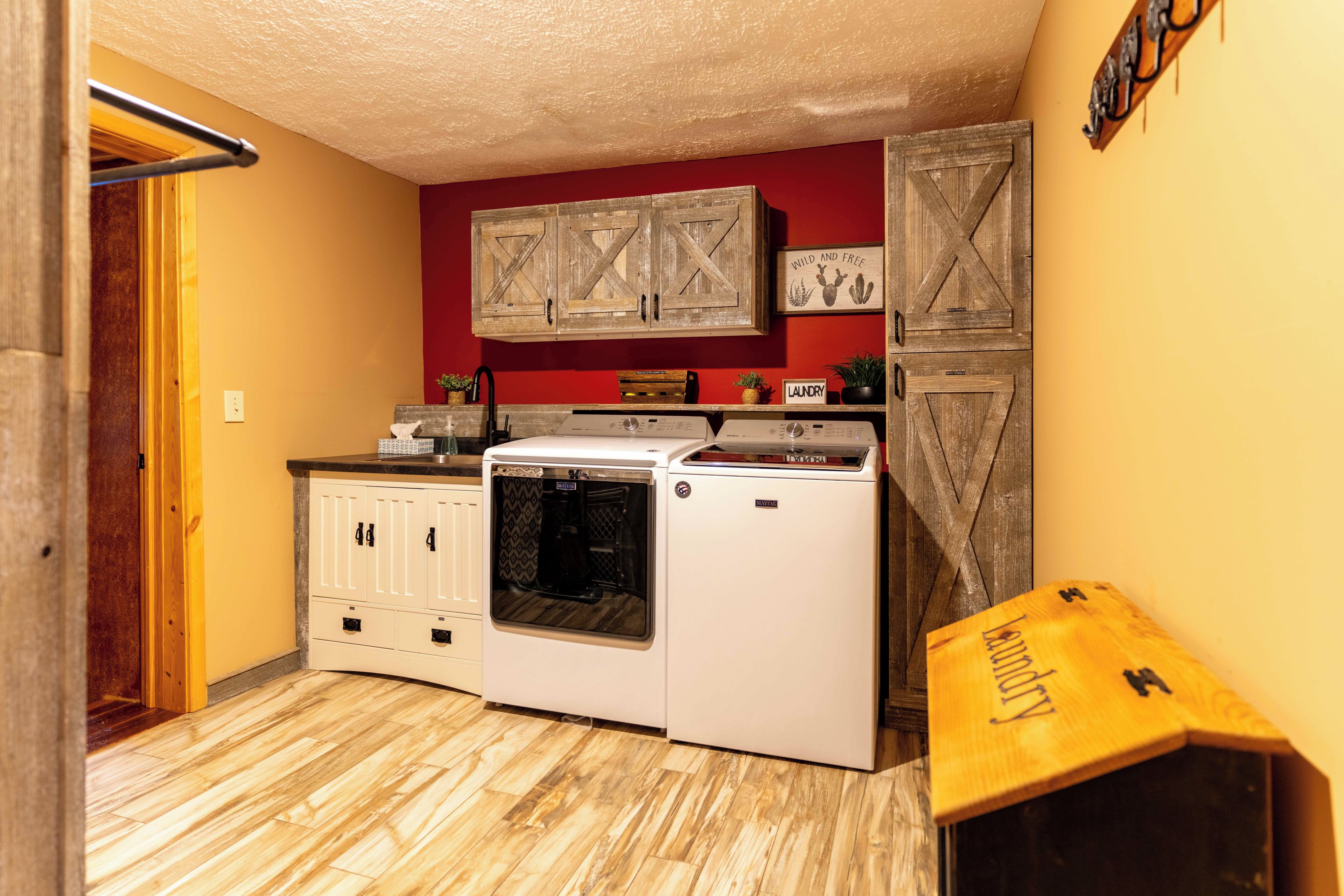 A compact kitchen with a washing machine, a dryer, and wooden cabinets.