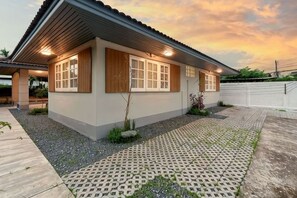 A modern house with a tiled patio, a wooden fence, and a well-maintained garden. - AIRI Home,3BR near Thapae and walking str old town CNX (Chiang Mai)