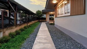 A pathway leading to a building with a covered area and a carport. - AIRI Home,3BR near Thapae and walking str old town CNX (Chiang Mai)