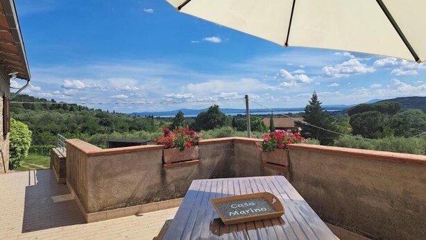 A terrace with a table labeled "Casa Marino," overlooking a scenic landscape. - Marino House (Tuoro Sul Trasimeno)